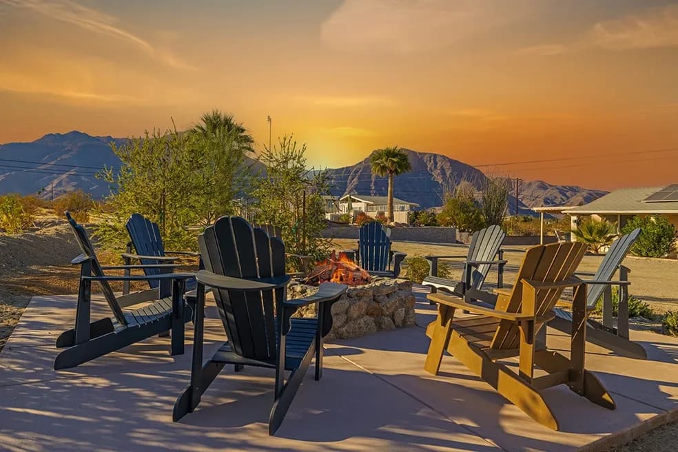 The motel courtyard firepit at golden hour, with the mountains beyond